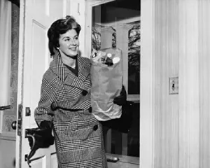 Posterazzi Mid adult woman holding a paper bag and entering a room Poster Print, (18 x 24)
